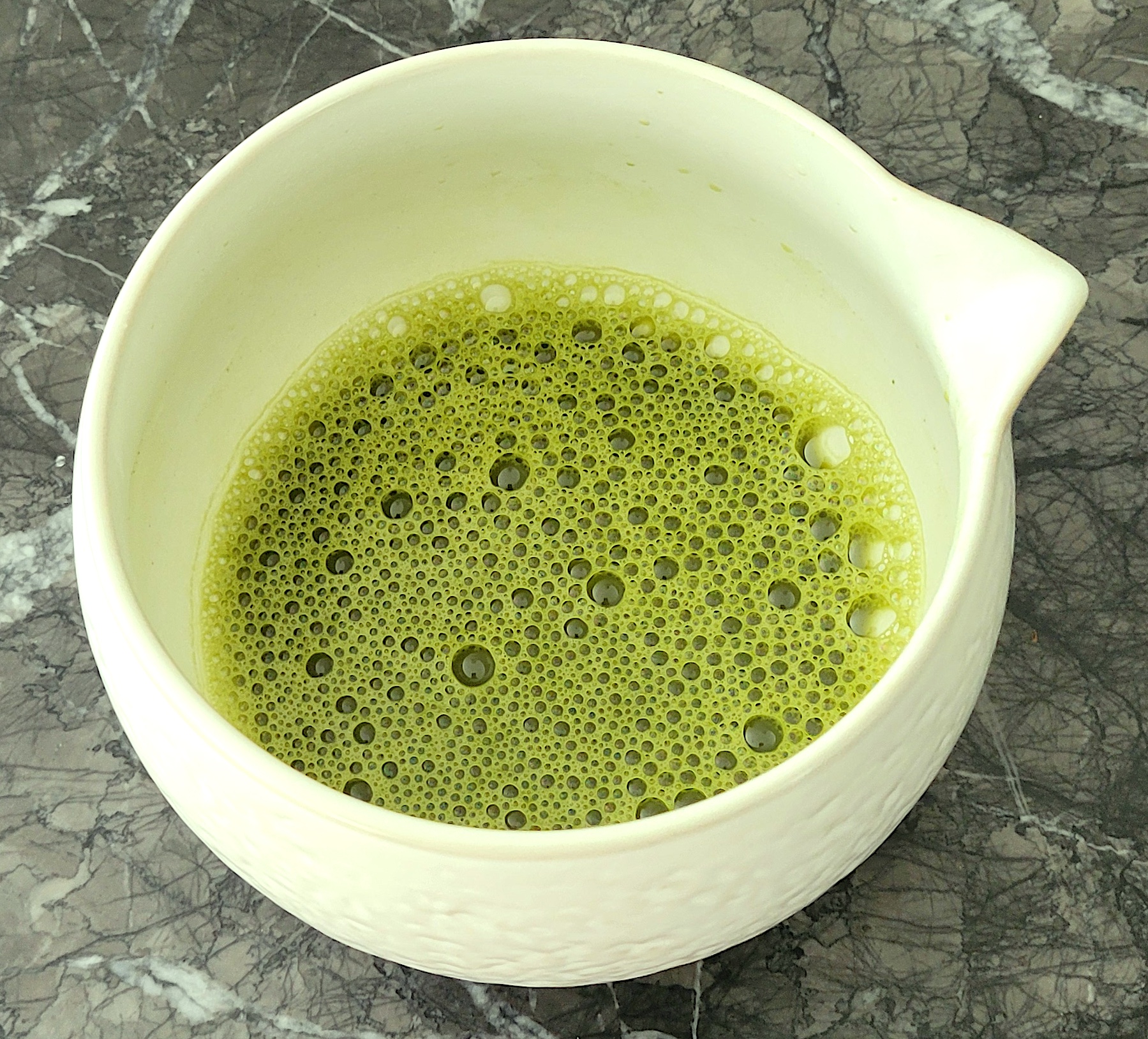 Bowl of thinly whisked matcha with a fine layer of bubbles on the surface